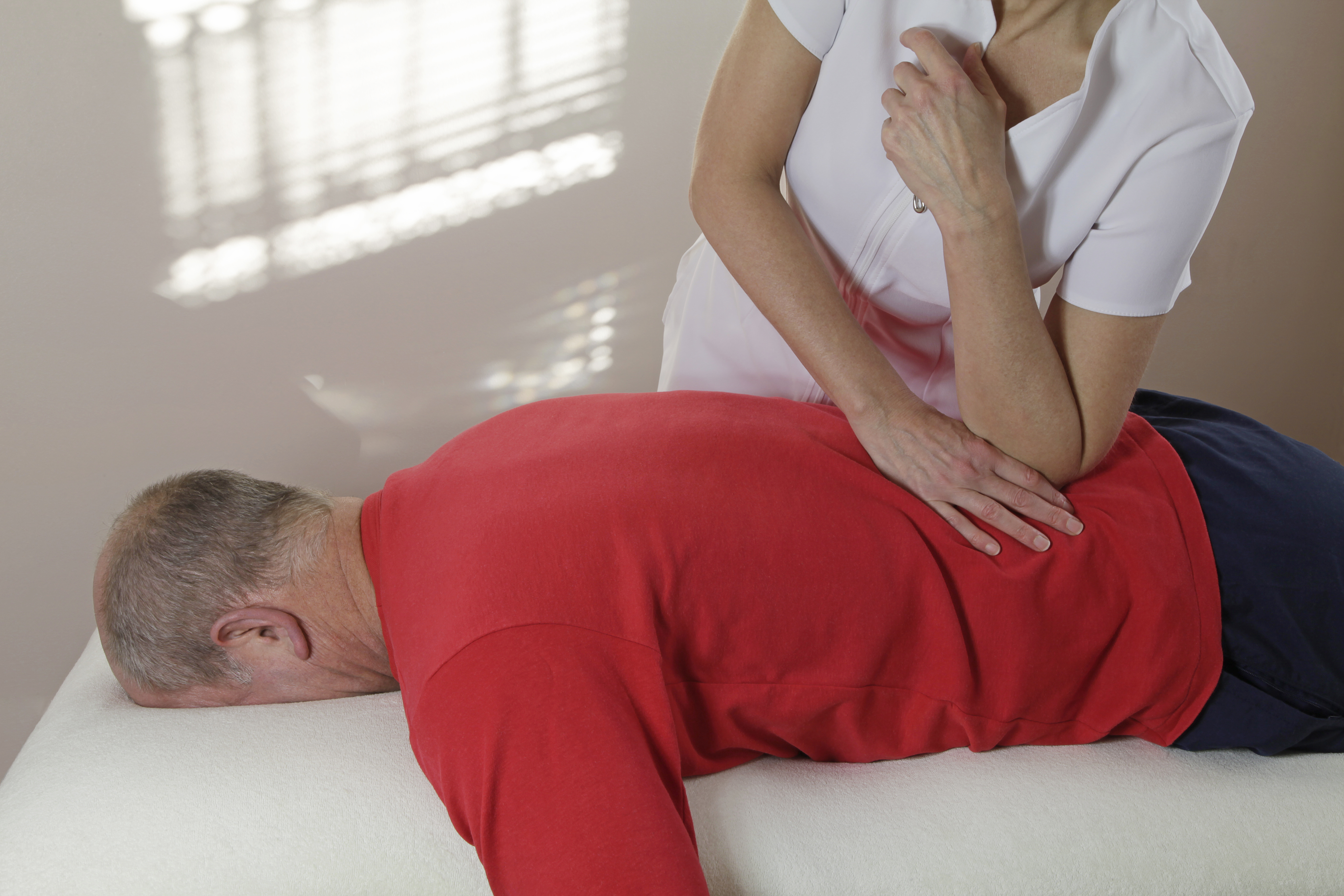Applying pressure with elbow into lower back